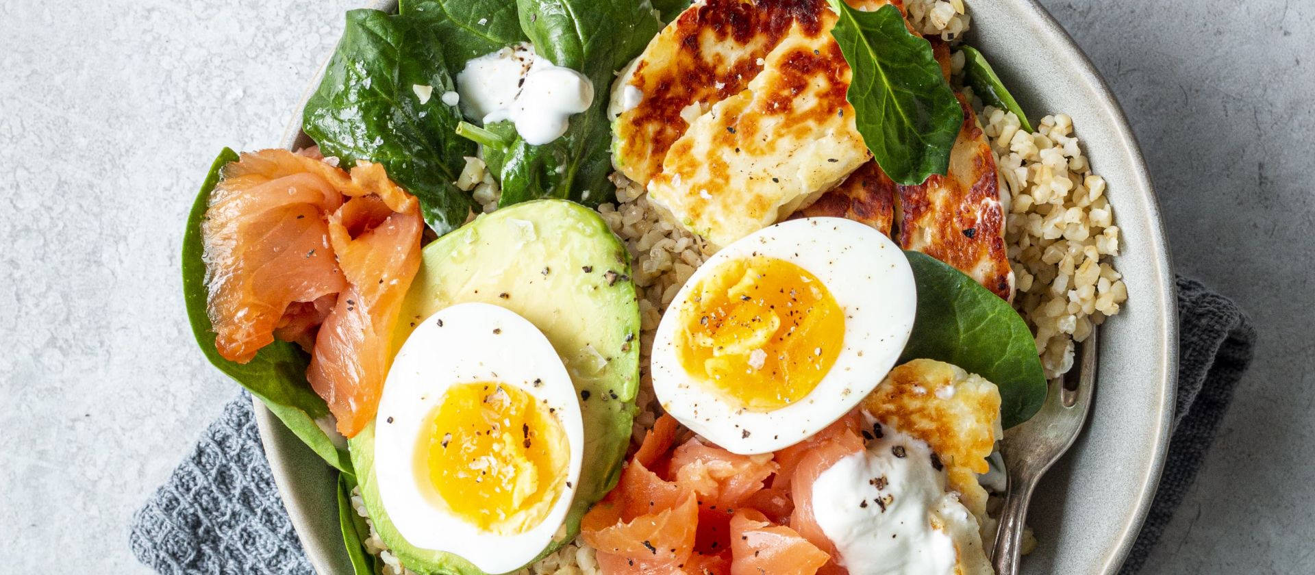 Bulgur-Bowl mit Avocado, Halloumi, Ei und Lachs